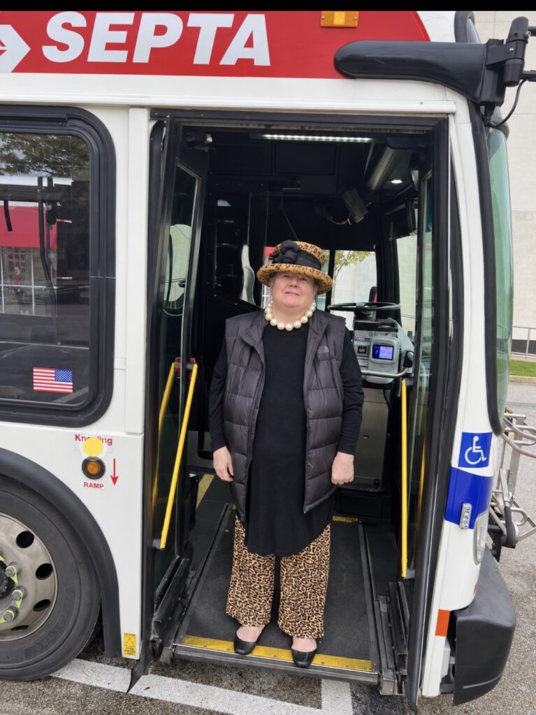 Realtor Michelle Leonard standing beside a SEPTA bus while exploring transportation options in Lower Merion and the Main Line.